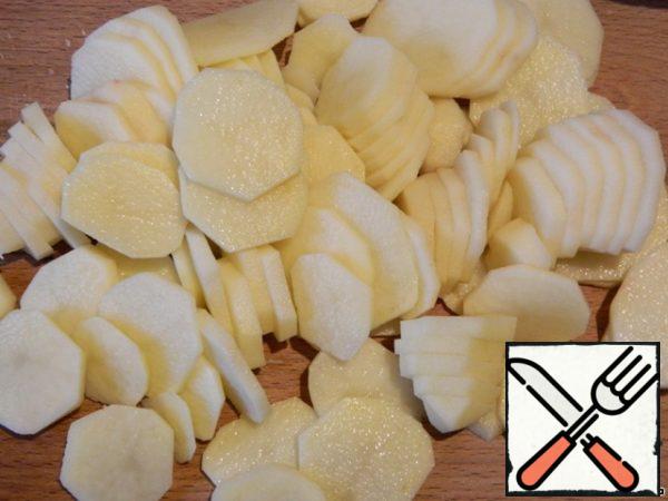 Peel the potatoes and cut them into thin circles. Potatoes it is advisable to take one size, but I have a different.