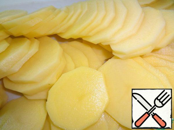 Potatoes peel, wash and cut into thin slices of about 3 mm.