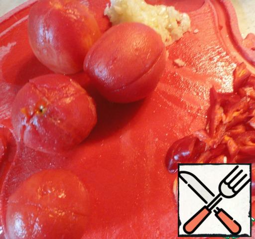 Garlic finely chop with a knife. Tomatoes cut crosswise, pour boiling water for 1-2 minutes. Remove the skin. Chilli cut into strips. If you do not want sharp or cook for children, do not add chili.