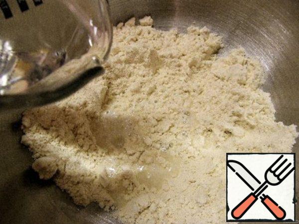 Add all the water and quickly knead the dough with your hands or with a fork. It is better to interfere in a bowl in a circular motion, removing the flour stuck to the edges.