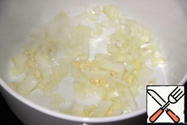 Finely chop the peeled onion and garlic. In a saucepan, heat the oil and quickly put them out until transparent.