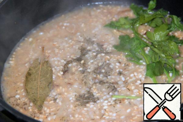 Add the broth. Add sprigs of parsley, thyme, salt, bay leaf and cook over low heat until the liquid evaporates and the rice is ready (about 15 min.)
