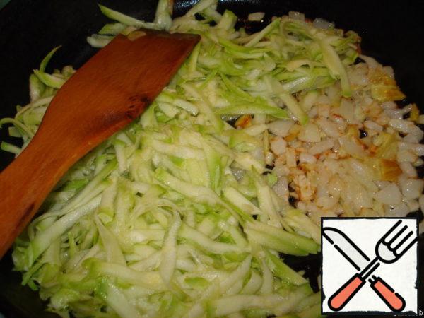 Add half of the grated zucchini (squeeze the juice) to the onion and fry on fire for 2-3 minutes.
