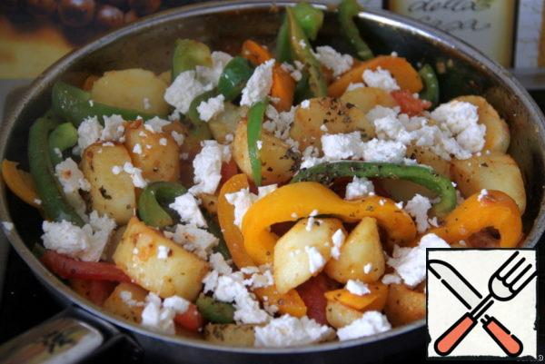 Season the vegetables in a frying pan with sweet paprika powder, salt, oregano and mix gently. Add tomato strips and crumbled cheese or feta.
