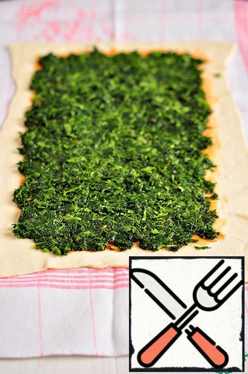 Put spinach on the dough, not reaching the edges of 1-2 cm.
