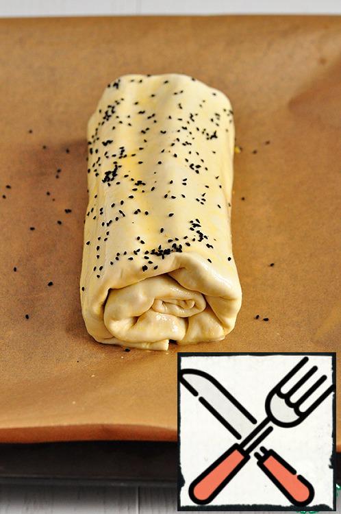 Roll to transfer on a baking sheet, covered with baking paper, grease with beaten egg on top, sprinkle with Nigella (sesame), and put to bake in a heated oven to 180 gr. for 25-30 minutes.