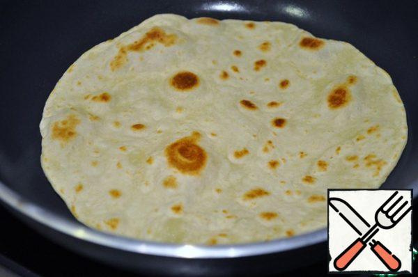 Take a dry frying pan with a thick bottom, heat it not very much and fry each tortilla for 2 minutes on each side.
