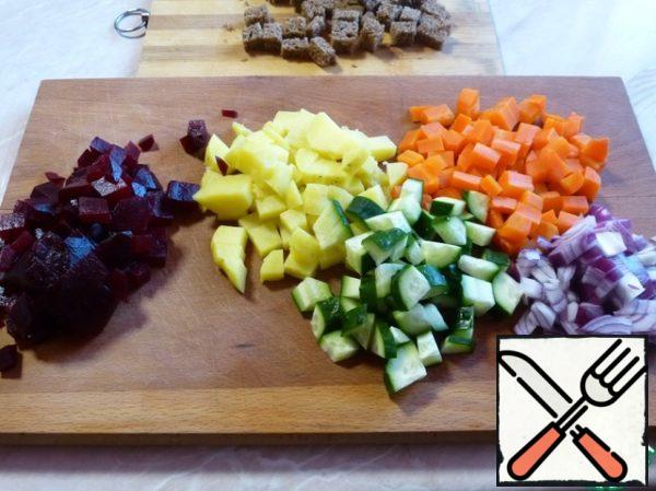 Dice potatoes, beets, carrots, onions, cucumber and gray Borodino bread.
Mix all the ingredients, put on a plate and decorate on your own. Before serving, pour a good olive oil.