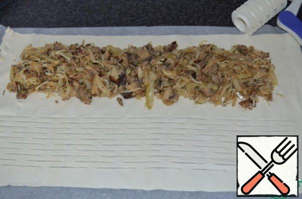 On the edge of the puff pastry (leave on three sides a couple of centimeters) to put ready-made minced meat. With such fixtures do cuts.
Can be not to do, this not necessarily, only for beauty!