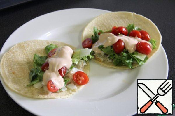 On half of the tortilla put the fish on top of chopped lettuce, halved tomatoes,
cover with the sauce.