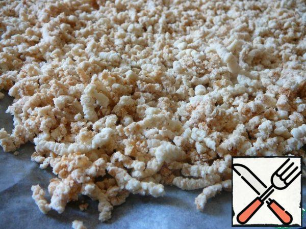 Tear a loaf of bread or a bun into pieces, dry it to a light golden color in the oven. Then grind into crumbs.
I put it through a meat grinder.
Grind the breadcrumbs with sugar.

