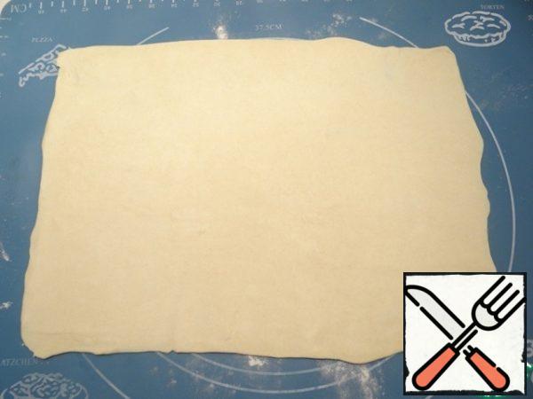 Sprinkle the table with flour, roll out the dough into a rectangle.
