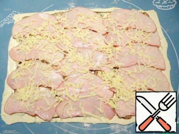 Mozzarella cheese rubbed on a coarse grater, sprinkle with half the slices of pork.