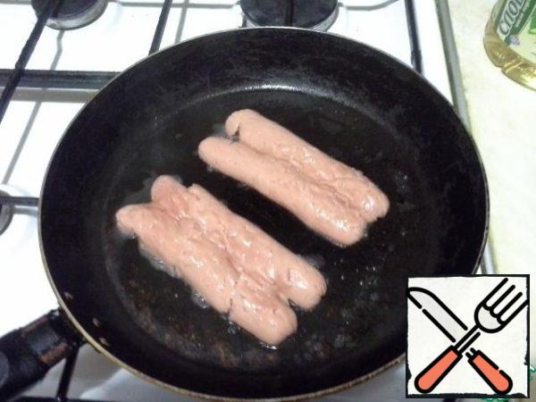Cut the sausages lengthwise, spread and nail with a hammer so that the sausages do not turn out crispy when frying. Fry in a preheated frying pan with the addition of vegetable oil on both sides.
