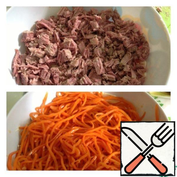 Next, a layer of diced meat and a thin layer of mayonnaise, Korean carrots in turn and also a thin layer of mayonnaise.
