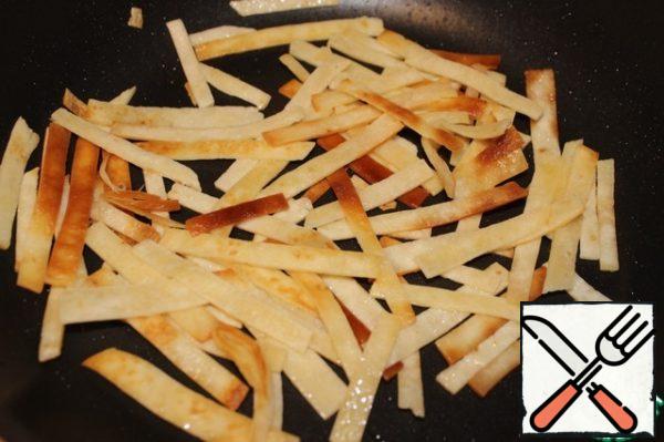Tortilla cut into strips, and fry until Golden brown in oil. Remove on a napkin to get rid of excess fat.