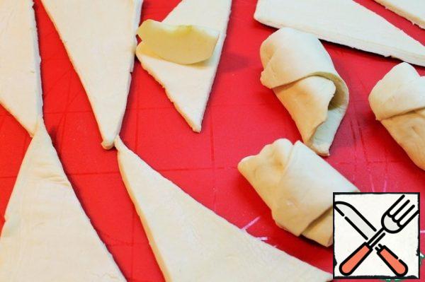 Cut the finished dough into triangles. Wrap an apple in each triangle.
