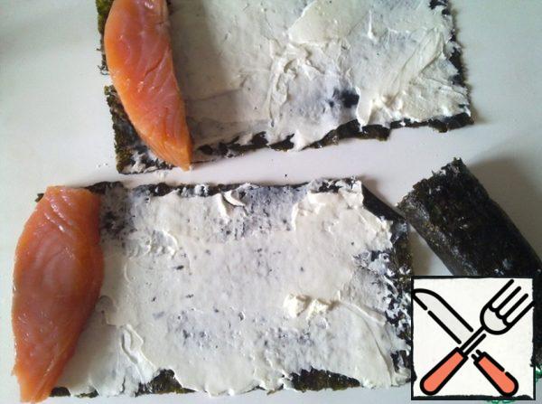 Fillet-a piece of salmon to peel and cut into 4 parts, wrap the fish in sheets of nori cheese.
