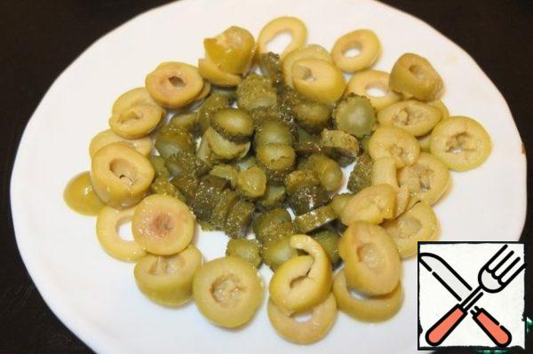 Gherkins and olives cut into rings.