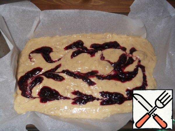 Spread the dough in the form. And on top of spoon spread a little jam (I take a jam tart). Then with a knife make stains.