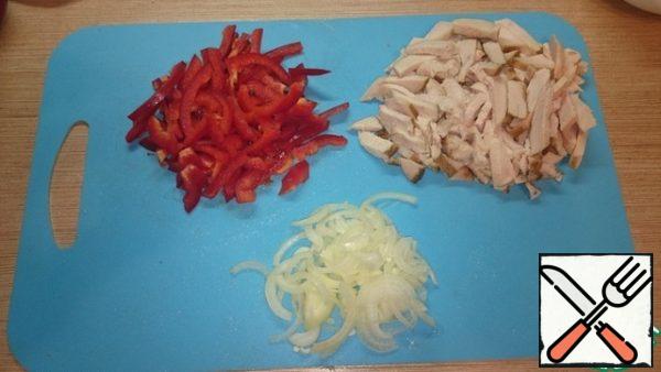 Cut the onion into half rings, pepper and chicken into strips.
