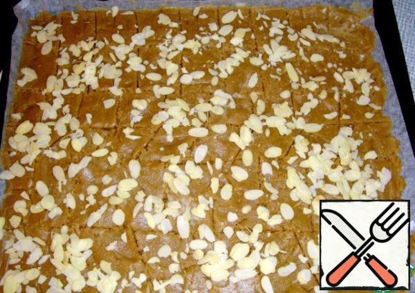 Put the dough on a baking sheet covered with parchment paper and level well. Can be cut into rectangular cookies. Top sprinkle with almond petals and put in a preheated oven 200 degrees for 10 minutes.