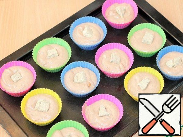Spread the dough into molds (12 pcs.). Fill out 2/3 of the form. If you have silicone molds, then you do not need to lubricate them with oil. Cut the halva into ~ 1.5 cm * 1.5 cm cubes with a hot knife and place the halva in the middle of the cake. Place a baking tray with cupcakes in a preheated oven to t 175 C for 20 minutes. check the readiness with a dry toothpick. The finished cupcakes are cooled in molds, and then taken out of them.
