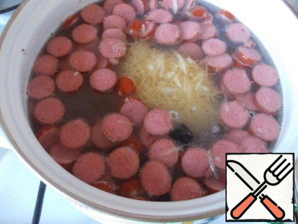 In the broth add the browned sausages, ham and noodles, cook for 5 minutes. Then add fresh tomato juice and olives, salt, pepper and cook for another 5 minutes.