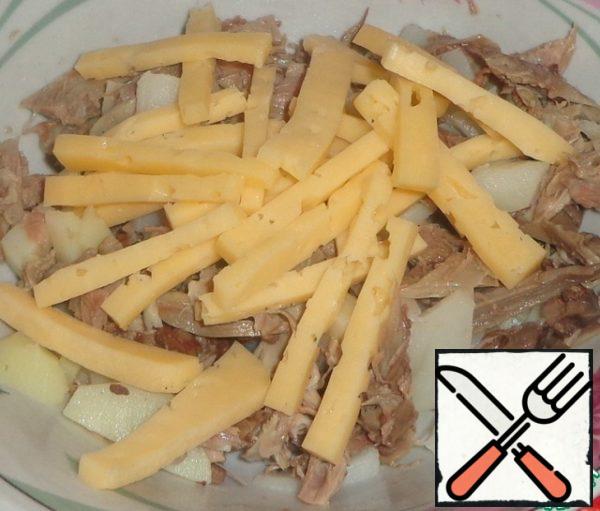 Cut the hard cheese into strips and add to the bowl.