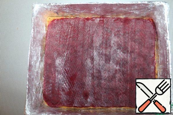 Put the first cake on the bottom of the mold, put cherry jelly on top.
