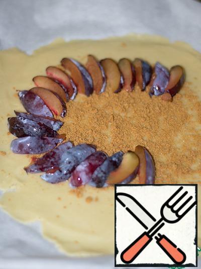 From plums remove the seeds, cut them in slices and lay on the cookie, leaving a rim of about 3-4 cm.