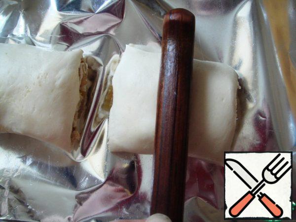 Cut the roll into 4-5 rolls, press the middle with the handle of a knife.
