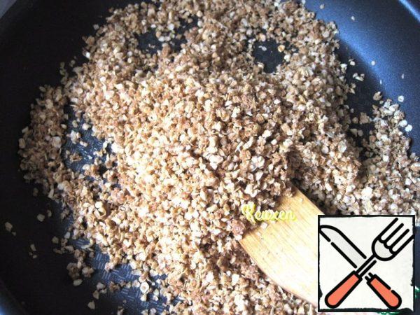 Next, put the prepared muesli on the pan and fry on a small fire, stirring constantly, until light Browning and before caramelization of the muesli (about 10 minutes). Put the muesli out of the pan and let it cool down.