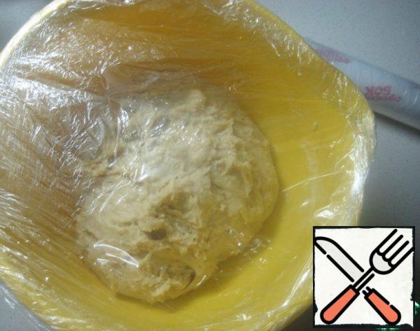 Tighten the bowl with the dough with a film and put it in a warm place for 1.5 hours to rise.
