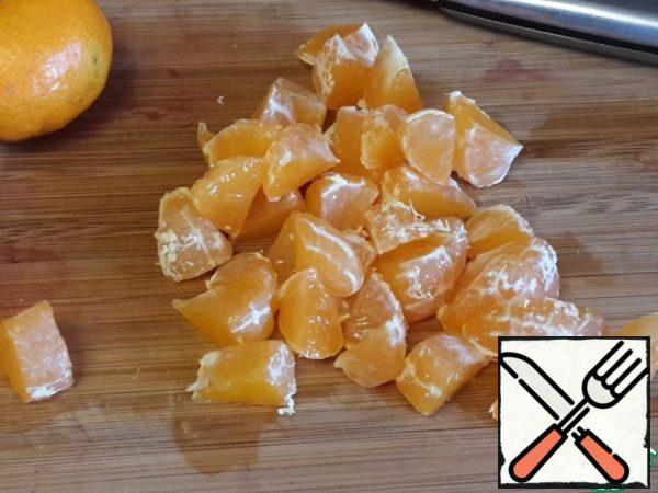 Disassemble the tangerine into slices. Cut each slice into 2-3 pieces.