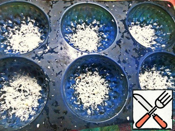 Pour coconut shavings into silicone muffin molds.
