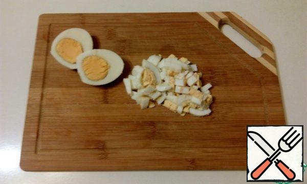 Boil the eggs, cool and cut into cubes.
