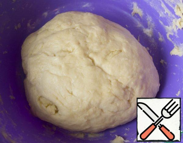 Mix flour with baking powder, sift to the liquid part. Knead the dough is not very steep. Place in a warm place for 2 hours.