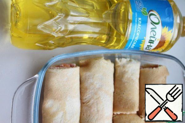 For the pancakes put the stuffing and wrap the tube. If desired, cut in half. Heat-resistant form grease with oil and lay the pancakes.