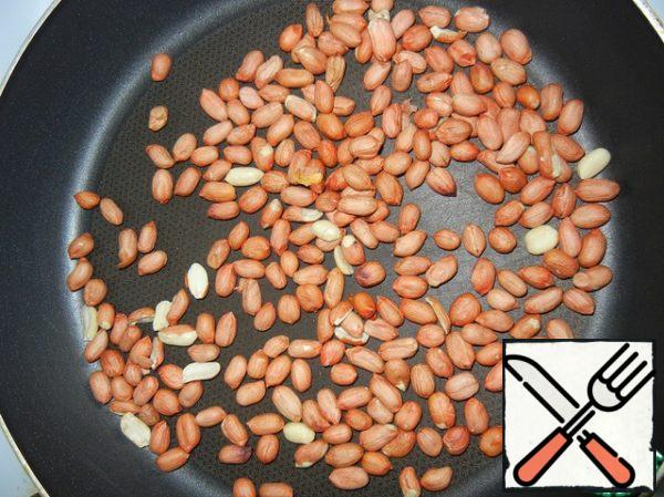 Fry the peanuts, stirring constantly. This can be done in a microwave oven, the cooking time will depend on the power of your assistant. On a wide plate, pour the peanuts in one layer and fry for about 1-1.5 minutes at 650 kW, then stir for another 1-1.5 minutes. Remove from the stove, wait until it cools down and clean.
