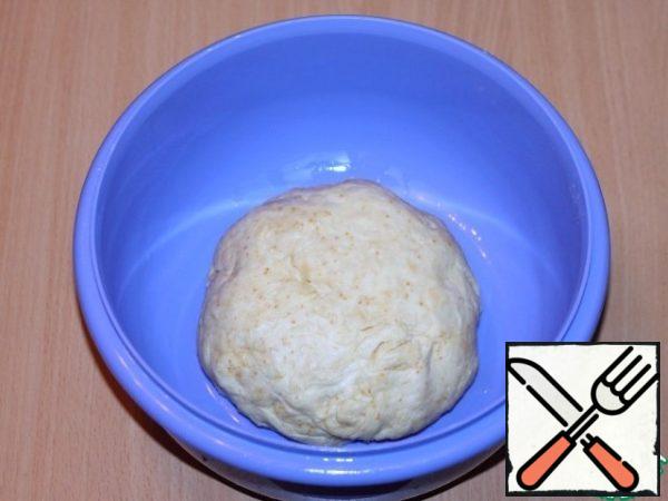 Knead the dough until it does not lag behind the hands. Cover the dough with a film and put it in a warm place to rise 2 times.
