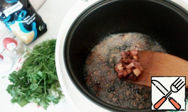 Turn on the slow cooker for frying for 20 minutes. I poured some sunflower oil on the bottom. After the signal that the slow cooker has warmed up and is ready to start frying, put the lard and, stirring, fry for 5 minutes.
