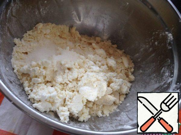 Grind the butter with sugar, a pinch of salt and vanilla sugar. Add the cottage cheese and once again all well grind until smooth.
Sift flour with baking powder. Gradually adding to the cheese-oil mass, turn it into a fairly large crumbs.