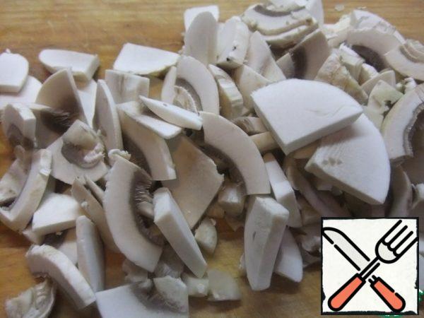 Wash the mushrooms and cut them into slices.