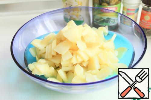 Boil the potatoes in their uniform. This can be done even in advance, for example, in the evening to boil, and in the morning to use. It is important to allow the potatoes to cool thoroughly, and then peel and cut into small pieces.