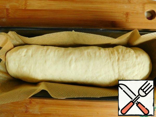 Fold the dough with the filling into a roll, shift into the form, cover and leave for 30-40 minutes to rise.