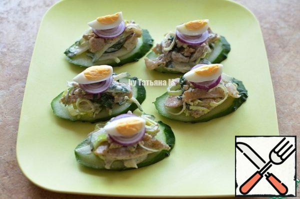 Place the cucumber base on a serving dish, place the salad on the base with a slide, garnish with red onion and a quarter of quail eggs;