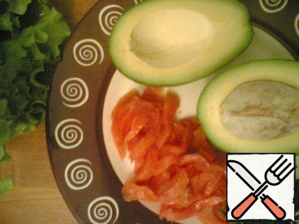 Weakly-salty trout (or salmon) cut into thin slices. Finely chop the greens. Cut avocado in half strictly in the middle lengthwise, remove the bone. Cut cucumber into cubes.