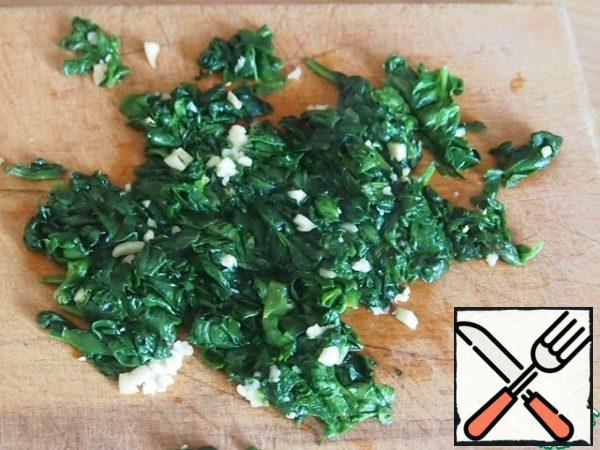 Then spinach mass cut into pieces and add to it finely chopped garlic.