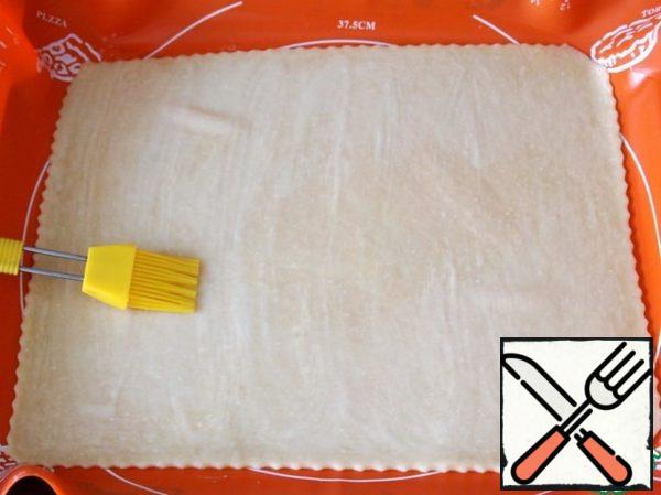 Roll out the dough (thickness not more than 5 mm.) on baking paper or silicone Mat. Transfer to a baking sheet. Grease with beaten egg (optional).